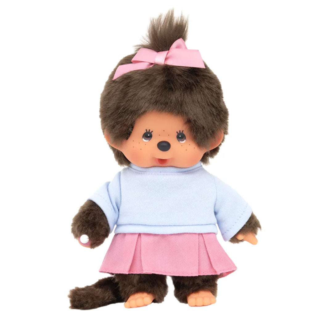 Sekiguchi Monchhichi Girl plush doll in pink pleated skirt, blue shirt, with thumb in mouth and pink ribbon updo