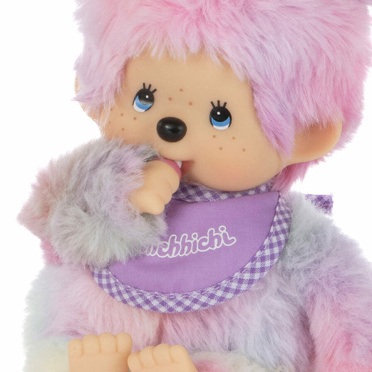 Sekiguchi Monchhichi tie-dye girl plush doll with thumb in mouth wearing purple bib close-up view