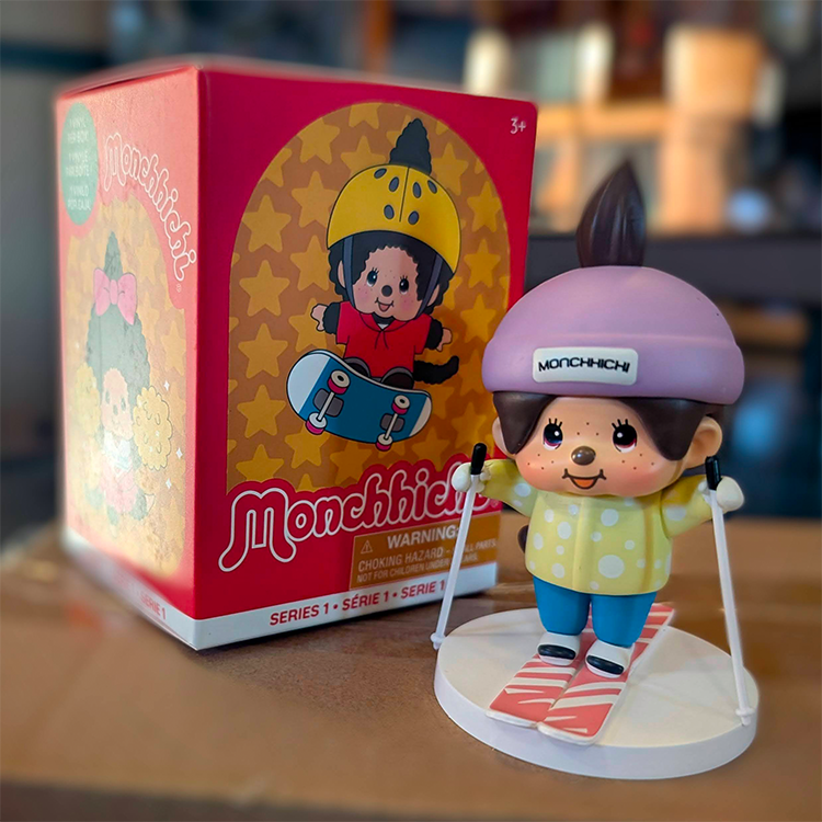 Sekiguchi Boy Monchhichi Skiing vinyl figure with purple helmet and yellow shirt on snow-themed base