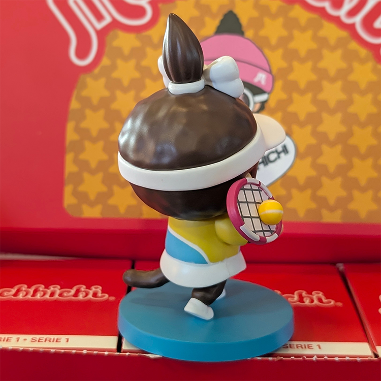 Sekiguchi Monchhichi Girl Tennis Player vinyl figure with racket and ball on blue court-themed base.