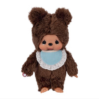 Brown bear Monchhichi doll wearing a blue polka dot bib with lace trim