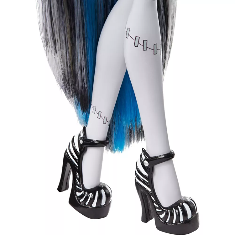 Close-up of Monster High Frankie Stein doll legs wearing black and white Mattel high-heeled shoes and stockings with stitch designs