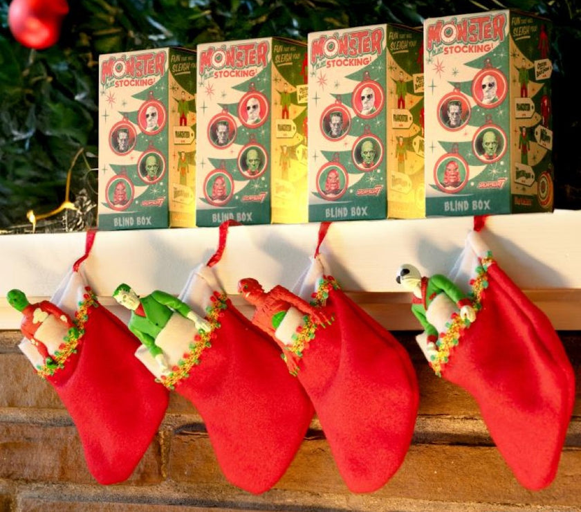 Hasbro Universal Monsters ReAction Monster In My Stocking blind box figures hanging in red stockings by fireplace.