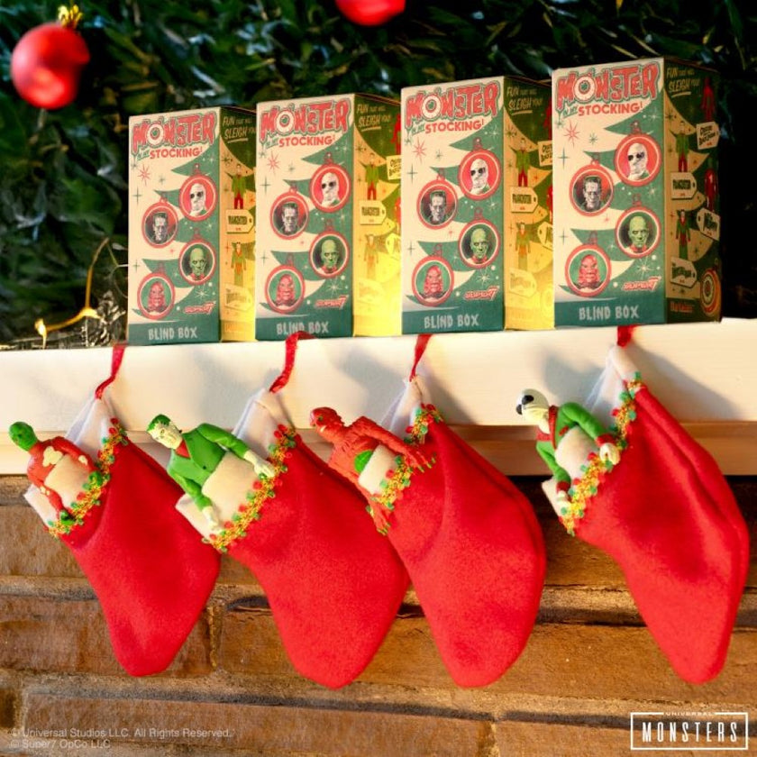 Hasbro Universal Monsters ReAction Monster In My Stocking blind box figures hanging in red stockings by fireplace.