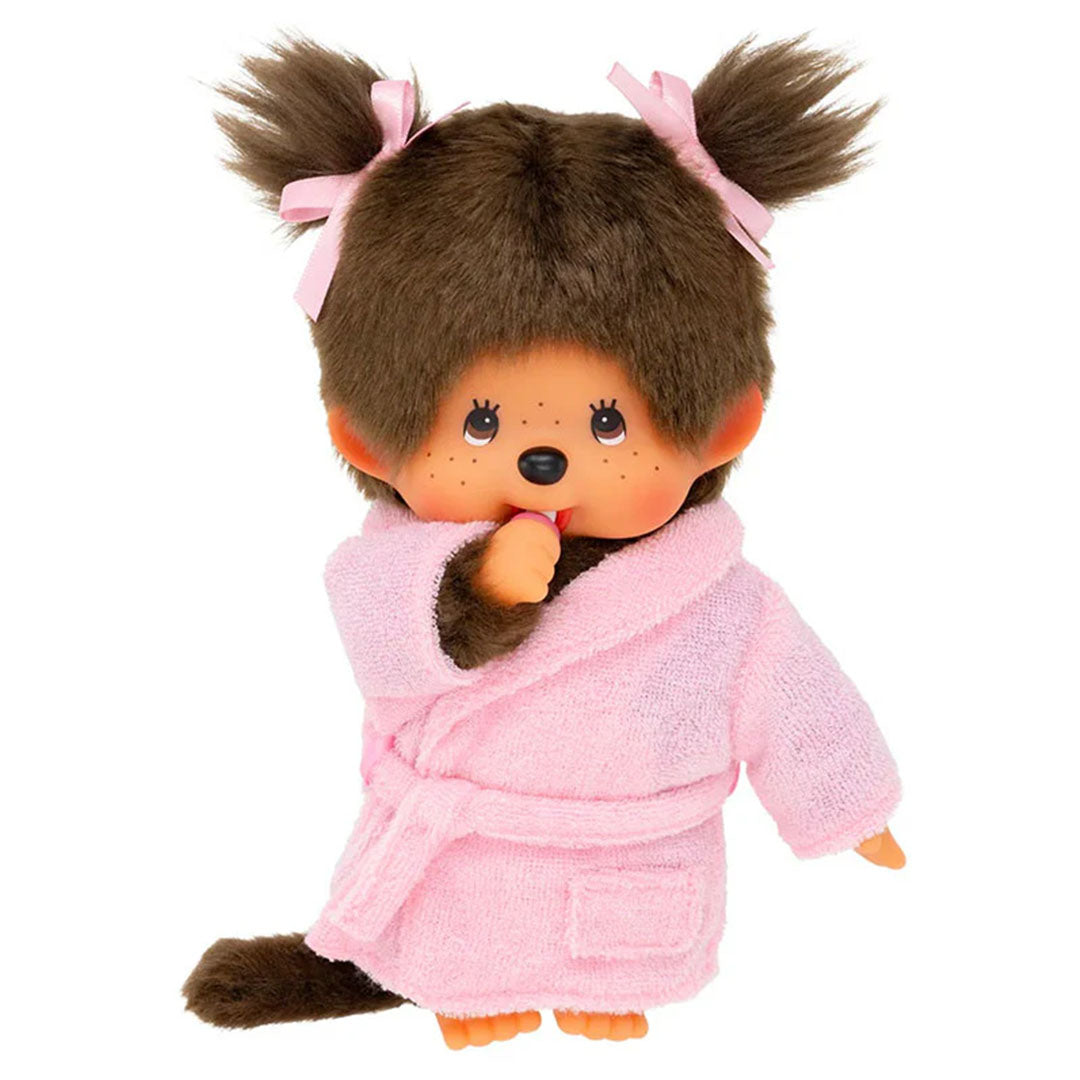 Sekiguchi Monchhichi Girl plush monkey in pink bathrobe with thumb in mouth and tied hair bows standing on white background