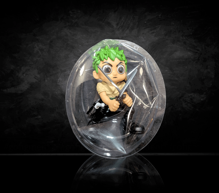 Go Figment One Piece mini figure Zoro with swords inside clear blind box packaging on black background