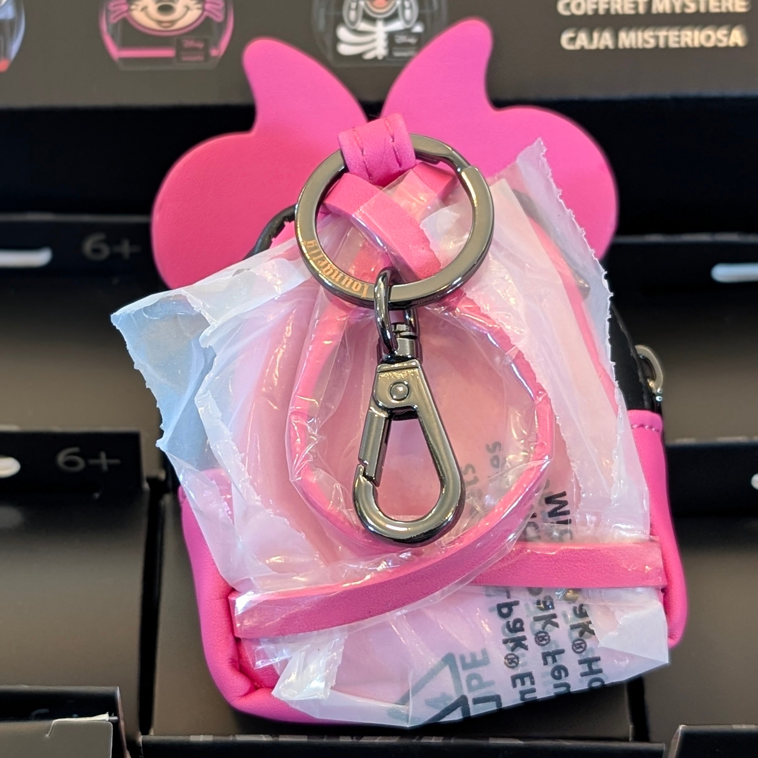 Pink Loungefly mini backpack bag charm shaped like Minnie Mouse’s ears with metal keyring and clip attached