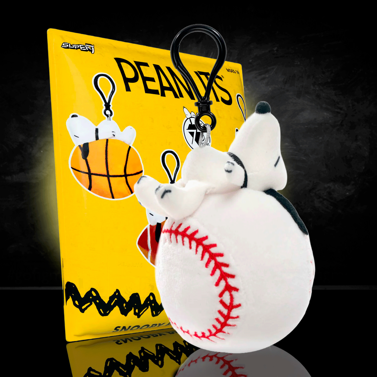 Go Figment Peanuts plush keychain featuring Snoopy on a baseball with black clip attached on yellow backing card
