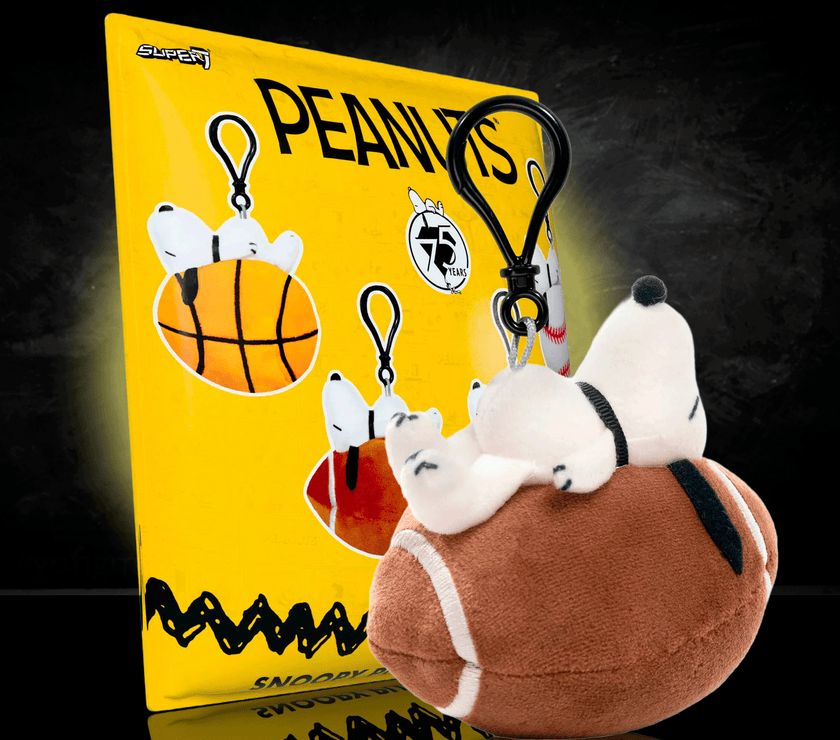 Go Figment Peanuts plush keychain featuring Snoopy lying on a football, sports-themed bag clip accessory.