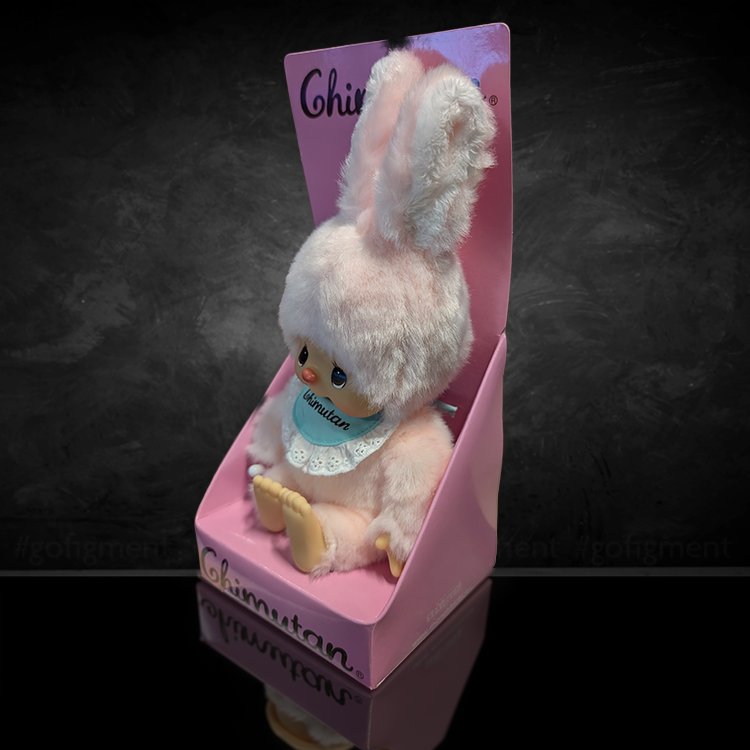 Sekiguchi Monchhichi Chimutan Bunny plush in pastel pink with blue bib seated in pink display box