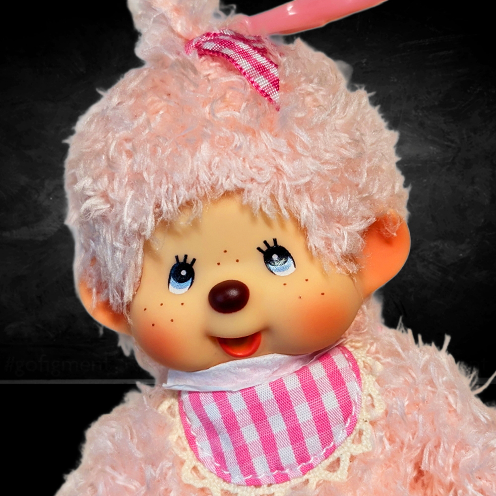 Sekiguchi Monchhichi 6-inch pink fluffy girl plush mascot clip with blue eyes and gingham bib close-up view
