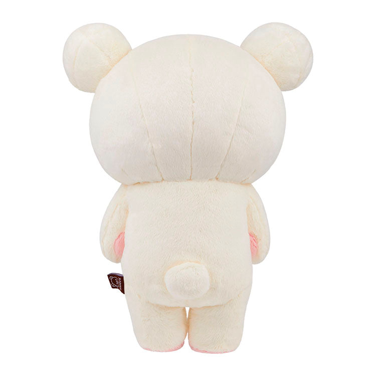 Back view of Korilakkuma plush from San-X in soft pink hearts sleeping bag design with zipper detail