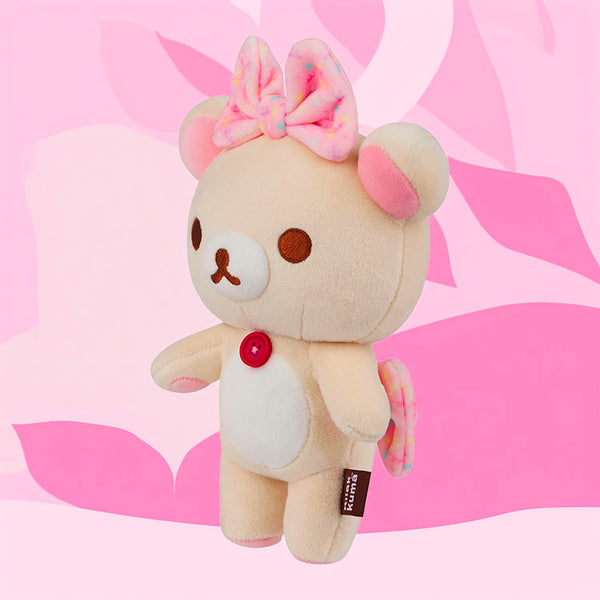 San-X Korilakkuma mochi plush mascot bear with pink bows standing against a pink background