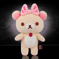 Korilakkuma plush mascot bear with pink bow by San-X, soft and squishy mochi design, 8 inches tall.