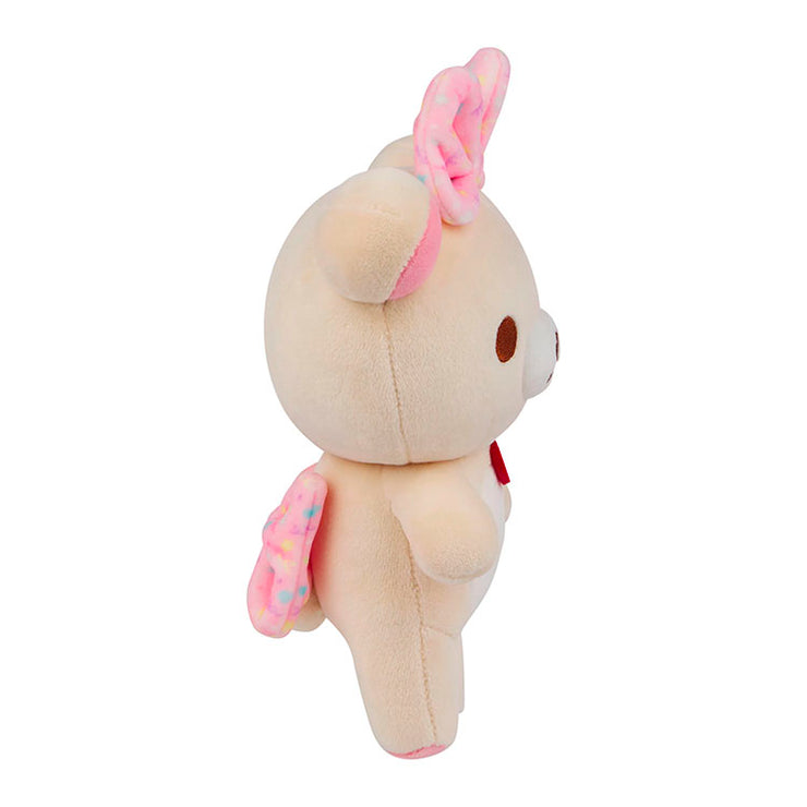 Side view of San-X Korilakkuma mochi plush bear with pink bows and soft beige fur on white background
