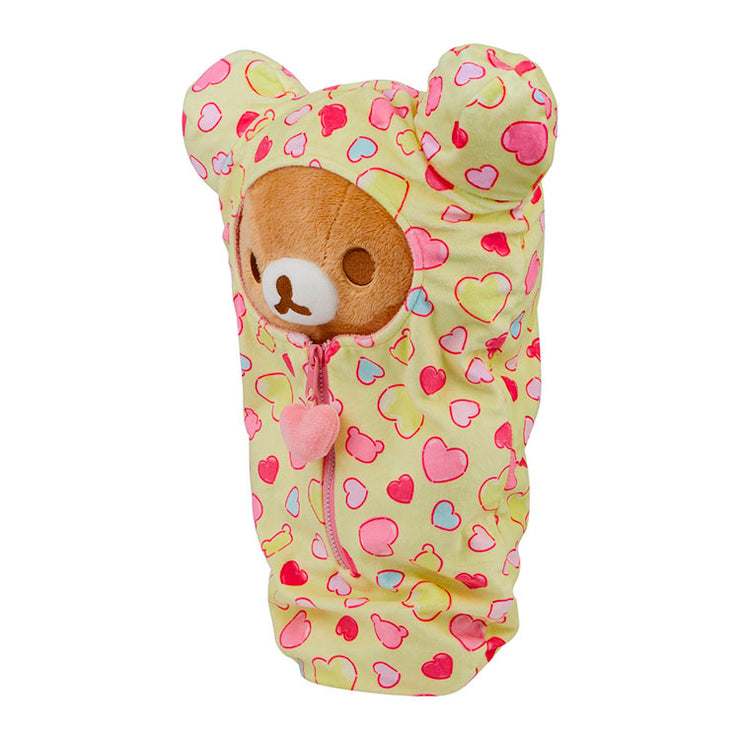 San-X Rilakkuma plush in a yellow heart-patterned sleeping bag with a front zipper cozy design