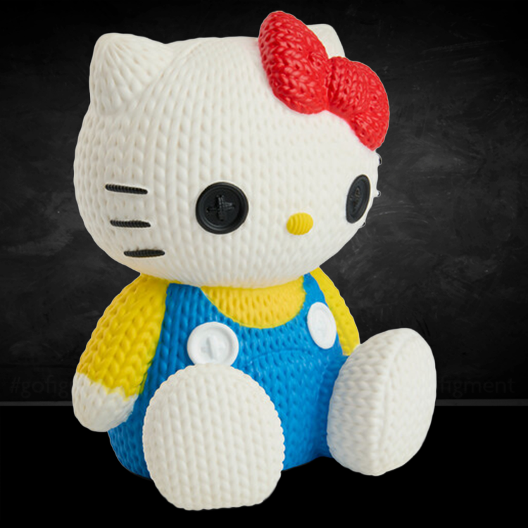 Handmade by Robots Hello Kitty figure in knit-inspired texture wearing blue overalls and red bow sitting on black background