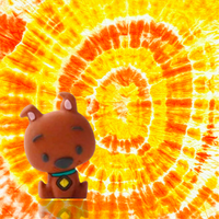 Scooby-Doo UCC 3D mini figure collectible with bright orange and yellow tie-dye background vibrant design