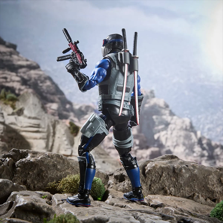 Hasbro G.I. Joe Classified Series Snake Eyes action figure posed with weapons on rocky terrain background.