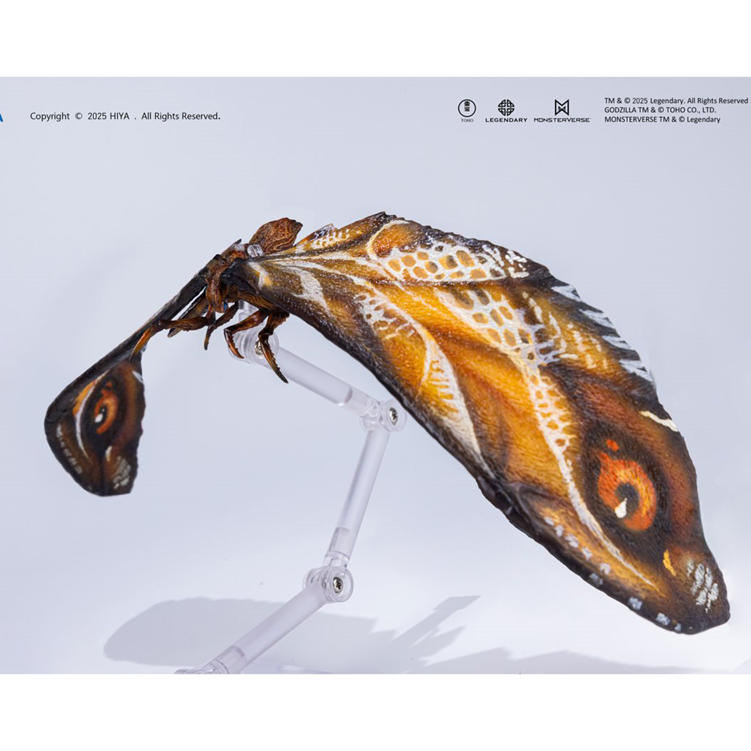 Articulated moth figure with brown and orange patterned wings displayed on clear adjustable stand against white background