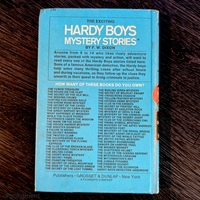 Back cover of vintage 1959 Hardy Boys book listing titles in white text on blue Grosset & Dunlap hardcover