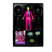The Joker Black Light Gold Label Mcfarlane Action Figure 6" in packaging with accessories and comic-style sound effects.