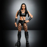 Female wrestling action figure in a black outfit, studded boots, and star-patterned tights against a dark studio backdrop