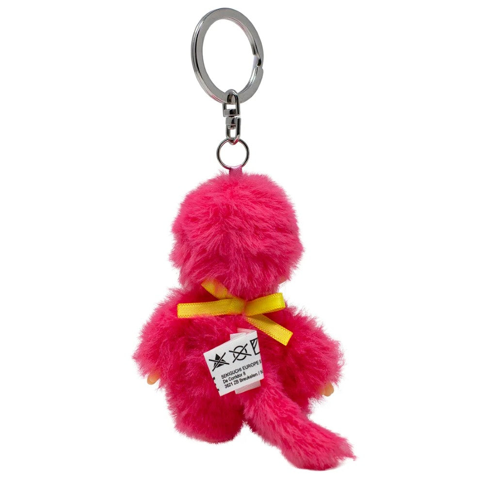 Pink fuzzy monkey keychain with a yellow bow and long tail on a white background