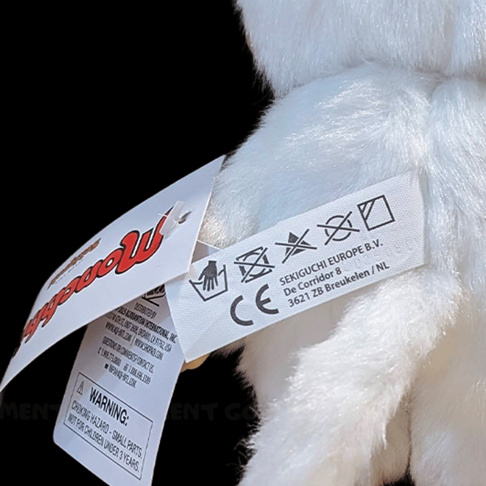 Close-up of Sekiguchi Monchhichi white cat plush tags showing care instructions and brand information