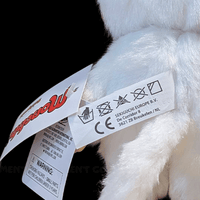 Close-up of Sekiguchi Monchhichi white cat plush tags showing care instructions and brand information