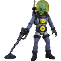 Green alien astronaut figure holding a handheld metal detector beside a circular sensor coil