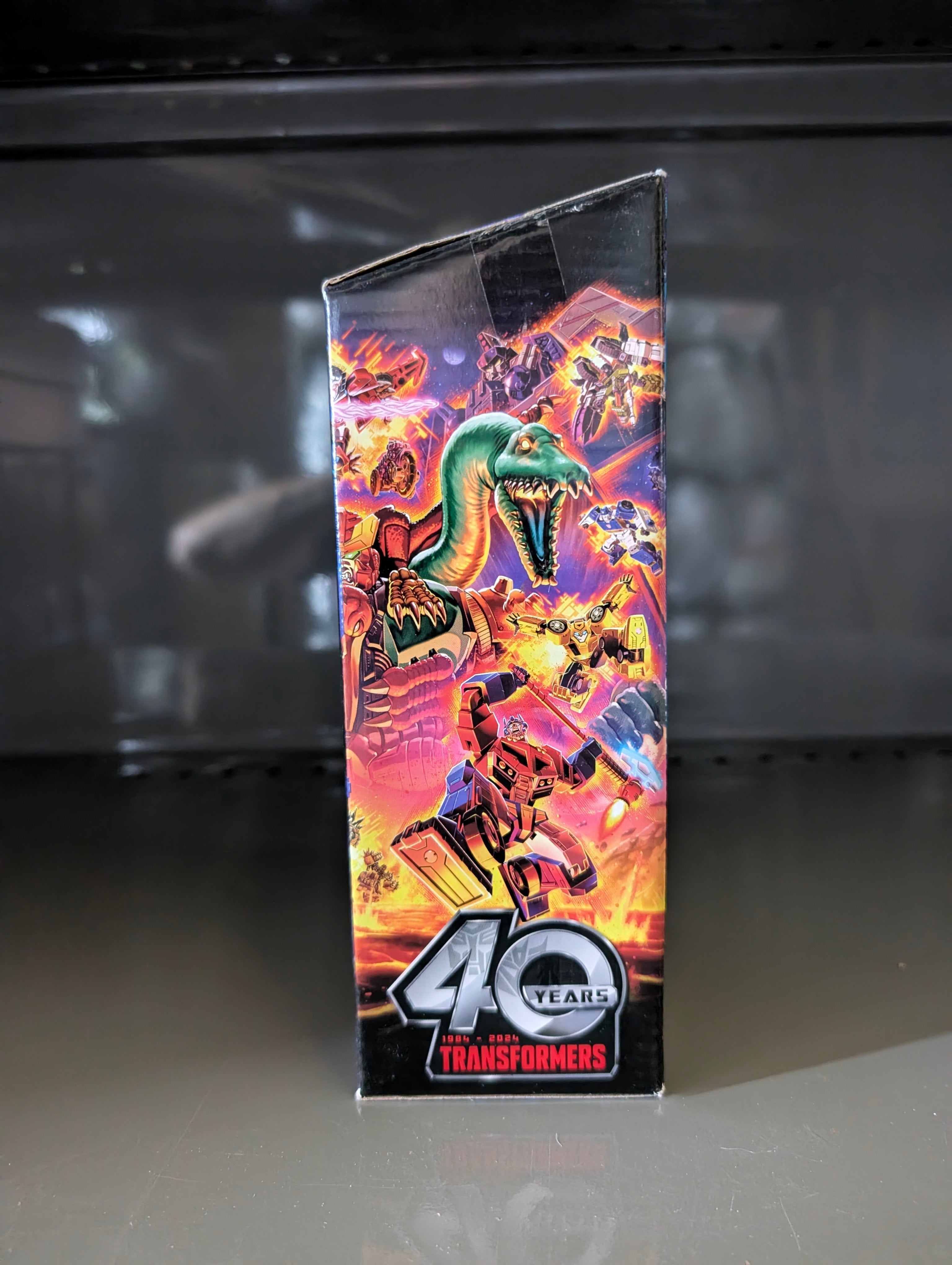 Voyager Star Raider Transformers Legacy United Collectable Action Figure packaging side with retro robot and dinosaur art by Hasbro.