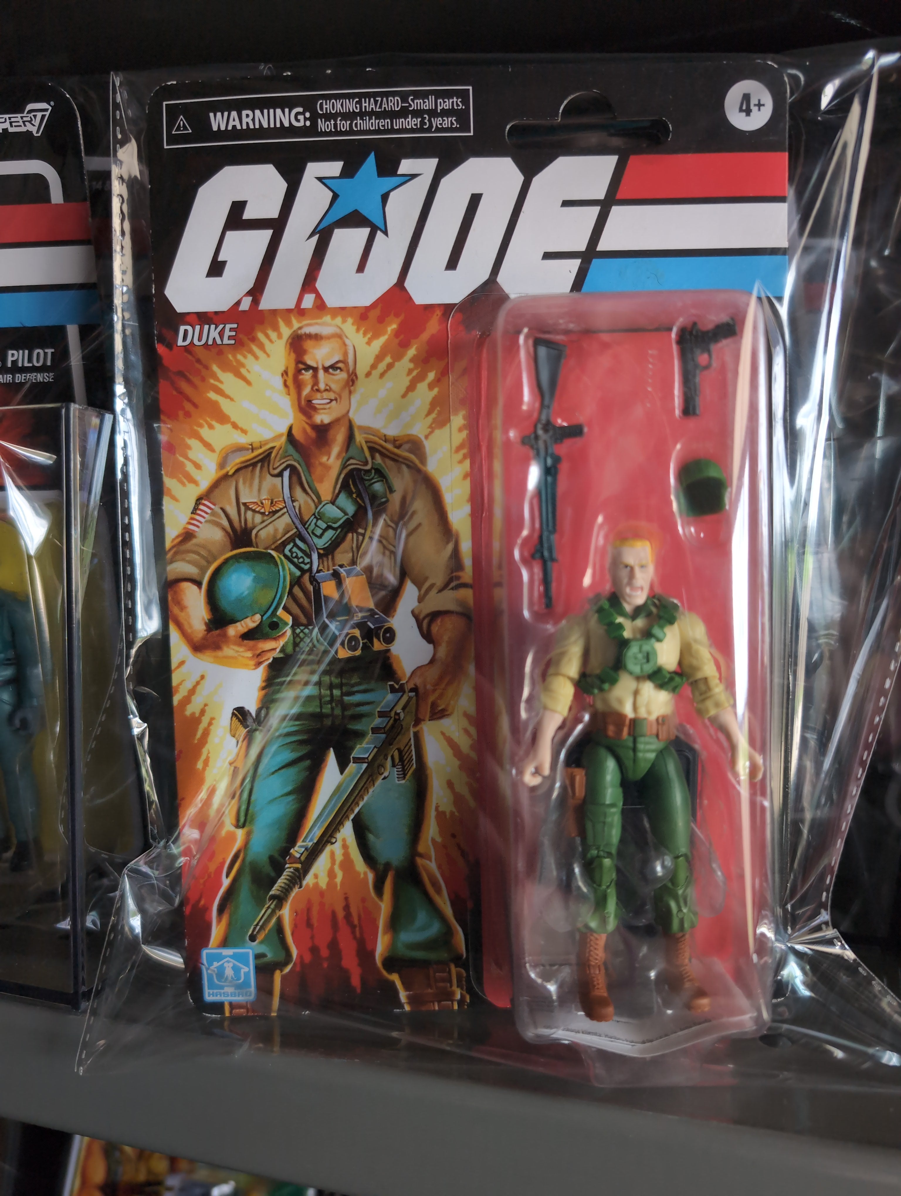 GI Joe Duke action figure with weapons in retro Hasbro packaging featuring classic 1980s design and branding.