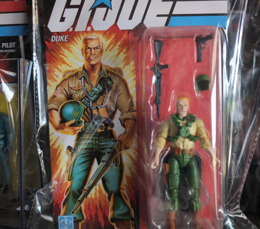 GI Joe Duke action figure with weapons in retro Hasbro packaging featuring classic 1980s design and branding.