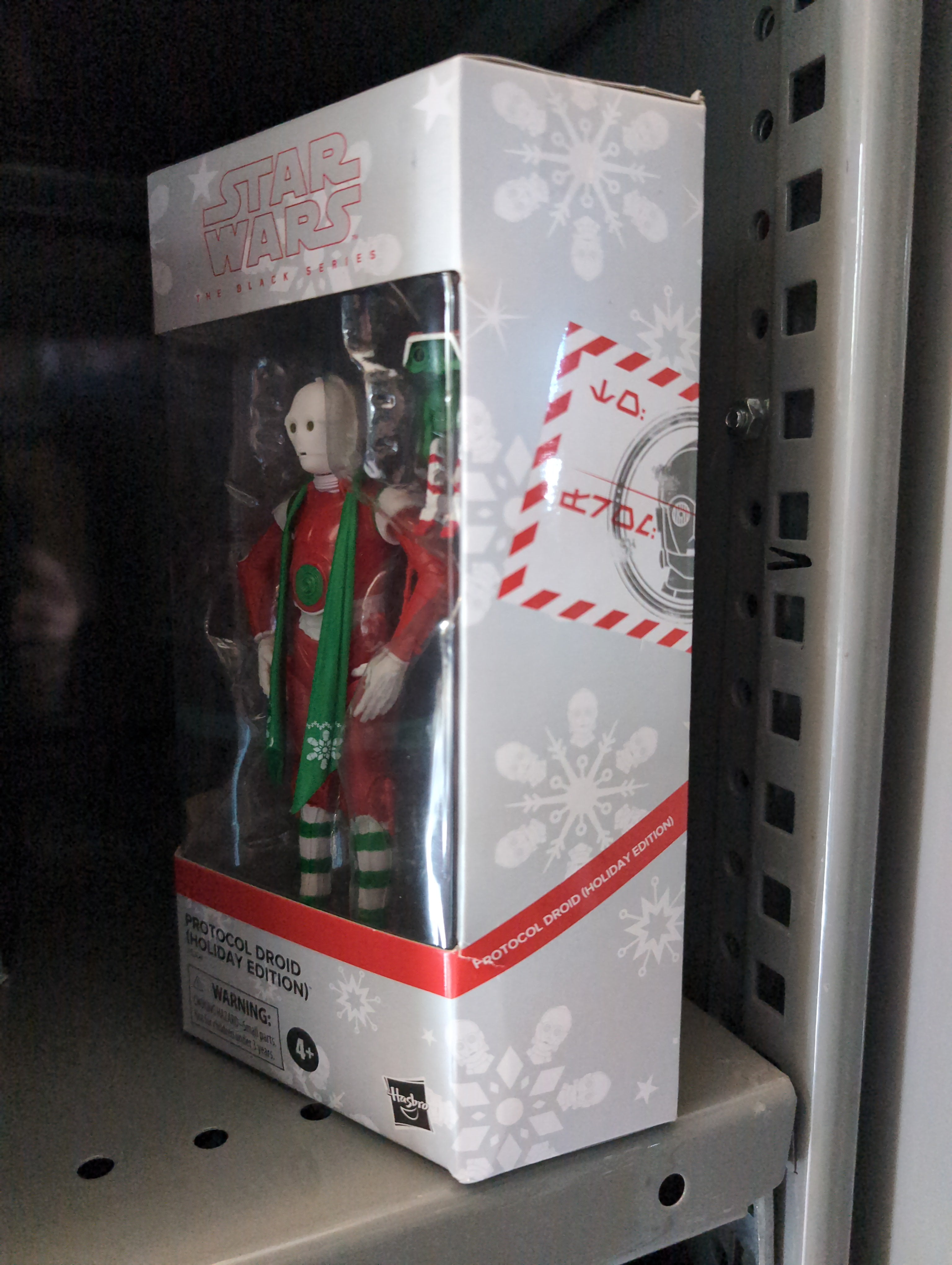 Hasbro Star Wars Black Series Christmas Protocol Droid action figure in festive holiday packaging on store shelf.