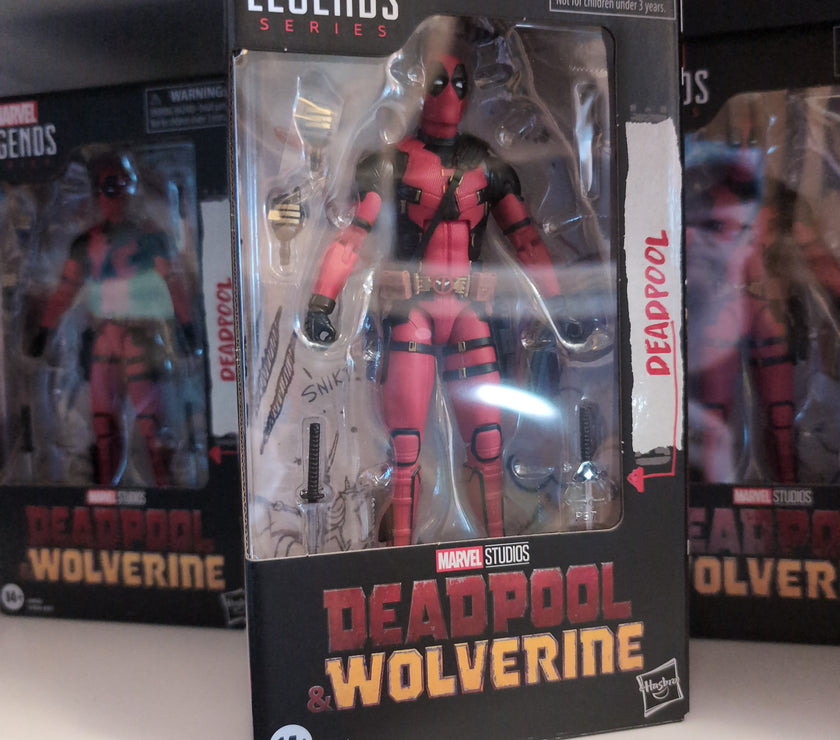 Deadpool action figure in red and black suit packaged in Marvel Legends box by Hasbro on a store shelf