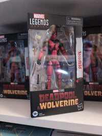 Deadpool action figure in red and black suit packaged in Marvel Legends box by Hasbro on a store shelf
