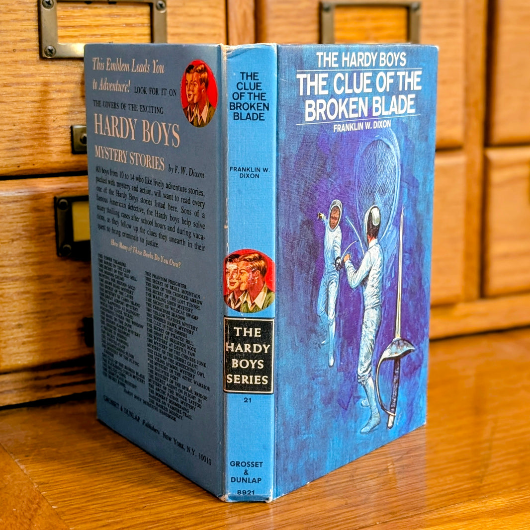 Hardy Boys book The Clue of the Broken Blade standing on wooden surface by Grosset & Dunlap Inc.
