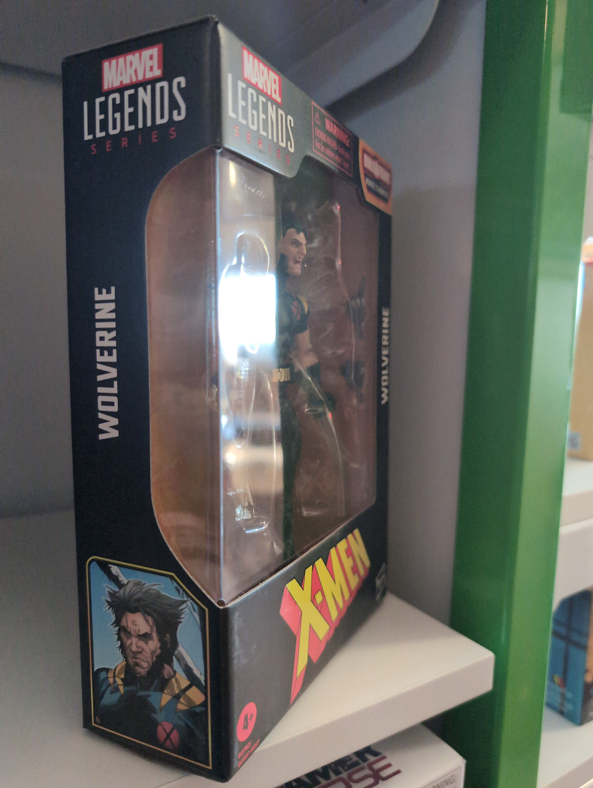 Hasbro Marvel Legends Wolverine X-Men 6-inch action figure in packaging with accessories visible on shelf