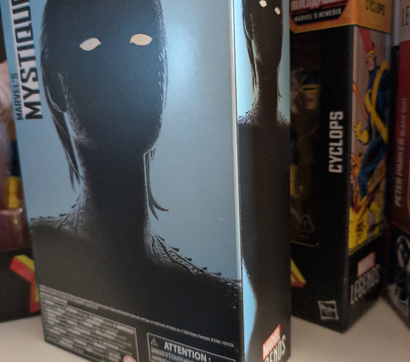 Hasbro Marvel Legends Mystique 6-inch action figure packaging showing shadowed silhouette with white eyes.